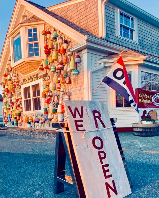 captain cass seafood restaurant exterior view of the buoys on the wall facing the setting sun